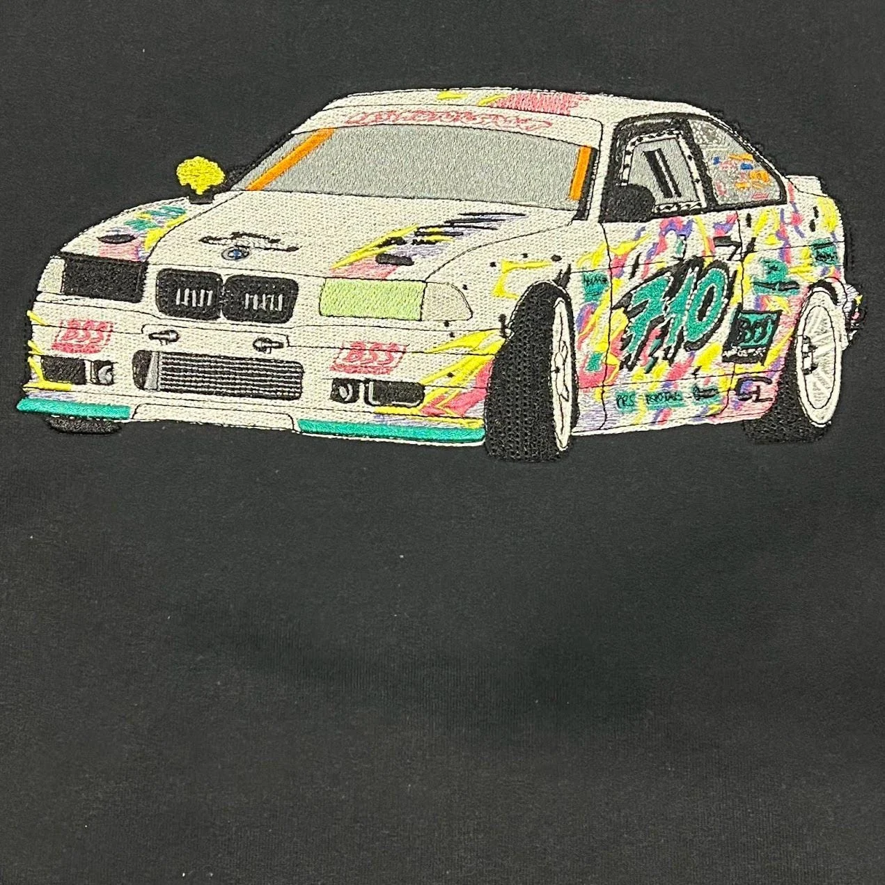 Detailed front three-quarter view of a stitched white drift car with pink, yellow and teal graffiti on black