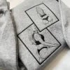 Grey sweatshirt angled to show two overlapping framed outline portraits of a woman from behind in black thread