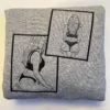 Folded grey sweatshirt with two overlapping framed black line-art figures stitched across the front