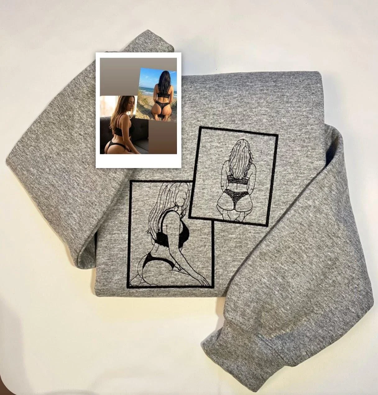 Folded grey sweatshirt with two framed line-art portraits stitched in black and the source photo print on top