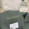 Light beige and military green pair with IX.VI.MMXXV in gold Roman numerals and gold D and B heart initials on the cuffs