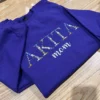 Angled view of floral AKITA lettering with tiny blue, white and pink flowers and mom script on a sweatshirt