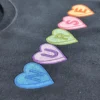 Detail of the stitched candy heart letters N U R S E on a navy sweatshirt, showing the satin fill and outlines
