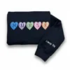 Folded navy sweatshirt with NURSE in candy heart patches and Liway RN embroidered in white on the sleeve