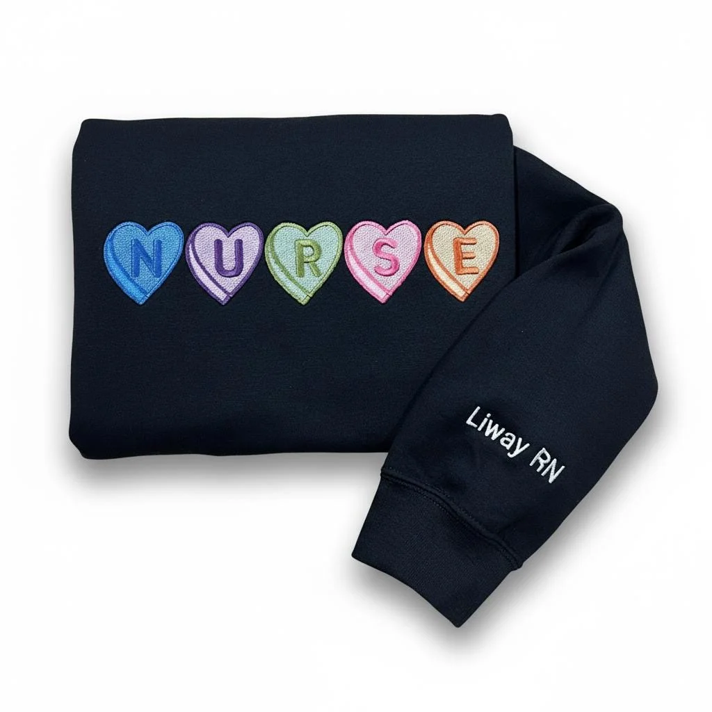 Folded navy sweatshirt with NURSE in candy heart patches and Liway RN embroidered in white on the sleeve