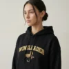 Woman wearing Wingleader embroidered dragon hoodie in black with gold embroidery