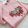Light pink sweatshirt with Nurse in red and green holiday-pattern letters, a red bow with stethoscope and snowflakes