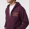 Man wearing a maroon full-zip hoodie with sample gold text CUSTOM TEXT OR LOGO embroidered on the chest