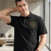 Man wearing a black pique polo with gold sample text Custom Text or Logo embroidered on the left chest