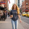 Woman walking down a city street in a slate blue T-shirt with small custom text embroidered on the chest