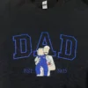 Dad portrait embroidery on a black sweatshirt: royal blue outline DAD and a dad holding a baby in blue, EST 2025