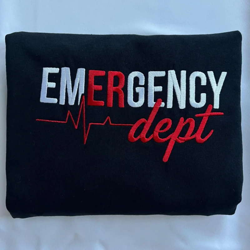 Folded black sweatshirt with white and red EMERGENCY lettering, heartbeat line and dept script