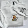 White sweatshirt with mama bear in black script around a yellow bear and Aurelia and Ayden stitched on the sleeve