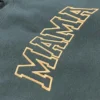 Close-up of arched MAMA varsity lettering with a gold outline embroidered on a forest green sweatshirt
