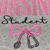 Close-up of the black script Student above a pink coquette bow with a grey and black stethoscope on grey fleece