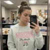 Student taking a mirror selfie in a study room wearing the grey NURSING Student bow stethoscope sweatshirt