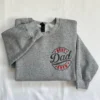 Sport grey sweatshirt with a round left-chest badge reading BEST Dad EVER in red and dark grey embroidery