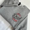 Grey crewneck showing the vintage style BEST Dad EVER badge with red block letters and a large Dad script