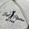 Angled close-up of the navy golfer embroidery with Best Pépère in script and BY PAR on heather grey fleece