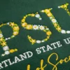 Forest green sweatshirt with school initials in yellow and white floral letters and a program name in gold script