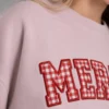 Close-up of red and white gingham applique letters with raised red satin stitch borders on a blush sweatshirt