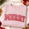 Blush pink crewneck with MERRY in red gingham applique letters with red satin edges, holiday flat-lay
