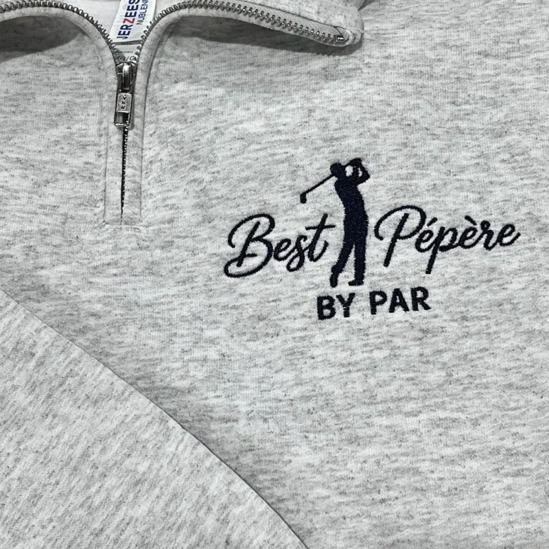 Ash quarter-zip with a navy golfer silhouette mid-swing between Best and Pépère in script, BY PAR below