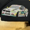 White sports car embroidered in the graffiti street art style, with pink, yellow and teal splashes and the number 710, on a black hoodie