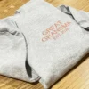 Grey sweatshirt laid diagonally with the coral GREAT GRANDMA and EST.2026 lettering across the chest