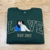 Forest green sweatshirt with LOVE in outline letters, a kissing couple portrait as the O and EST.2012 below