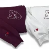 Maroon and white sweatshirts side by side, each with a two-bear outline on the chest and an initial with a red heart
